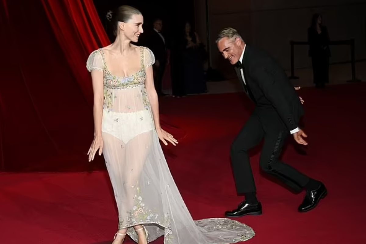 Joaquin Phoenix Fixes Rooney Mara’s Train at Academy Gala